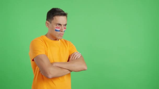 摄影棚里的录像 彩色的是一个男人 脸上涂满了杜鹃旗 表情严肃地望着别处 — 图库视频影像
