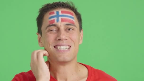 在演播室里用彩色的特写镜头拍摄了一个非常紧张的男人 他的脸上挂着一面挪威国旗 在一场最后以失败告终的艰难的比赛中 他支持着挪威队 — 图库视频影像