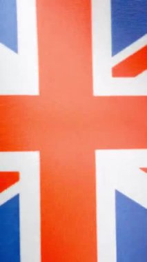 İngiliz bayrağının rüzgarla dalgalandığı stüdyoda dikey yavaş çekim videosu