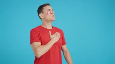 Stüdyoda, Kanada milli marşını dinleyen bir adamın renkli videosu.