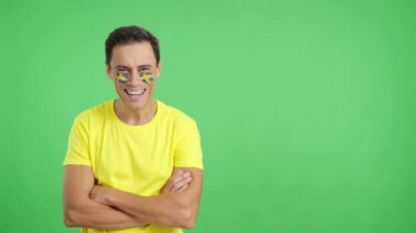 Stüdyoda, yüzünde İsveç bayrağı olan kollarını kavuşturmuş gülümseyen bir adamın kromasıyla.