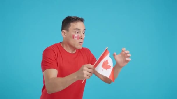 在演播室里播放的录像 画面中的一个男人一边看着一边挥动着一面加拿大国旗 一边对裁判的裁决感到愤怒 — 图库视频影像