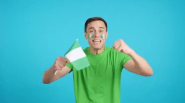 Stüdyoda, hakemlerin kararına kızmış Nijerya bayrağını sallayan bir adamın kromasıyla.