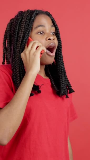 Überraschte Afrikanerin Spricht Studio Mit Rotem Hintergrund Mit Dem Handy — Stockvideo