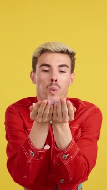 Feliz Gay Homem Soprando Confete Estúdio Com Amarelo Fundo — Vídeo de Stock