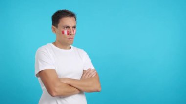 Stüdyoda, yüzünde Peru bayrağı olan bir adamın ciddi bir ifadeyle bakışlarını çevirdiği bir video.