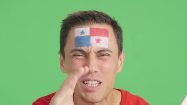 影片在演播室里的彩色特写是一名男子的近照 他的脸上挂着一面泛美洲国旗 以支持巴拿马队 — 图库视频影像