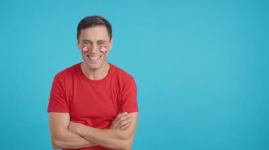 Stüdyoda, yüzünde İsviçre bayrağı olan kollarını kavuşturmuş gülümseyen bir adamın kromasıyla.