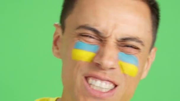 在演播室里拍摄的画面 画面上有一名男子的近照 他的脸上挂着乌克兰国旗 以支持乌克兰队 — 图库视频影像