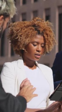 Dışarıdaki bir toplantıda tablet kullanarak fikir alışverişinde bulunan iş adamlarının videosu.