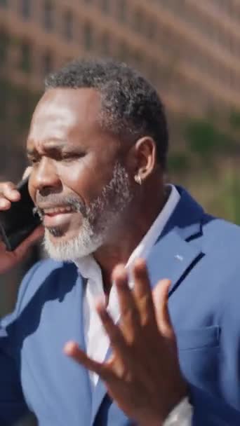 야외에서 전화로 말하는 걱정된 아프리카 사업가의 비디오 — 비디오