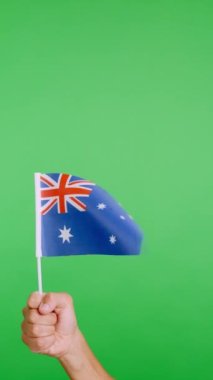 Stüdyoda ağır çekim bir elin krom rengiyle Avustralyalı bir flamayı kaldırırken rüzgarın el sallaması.