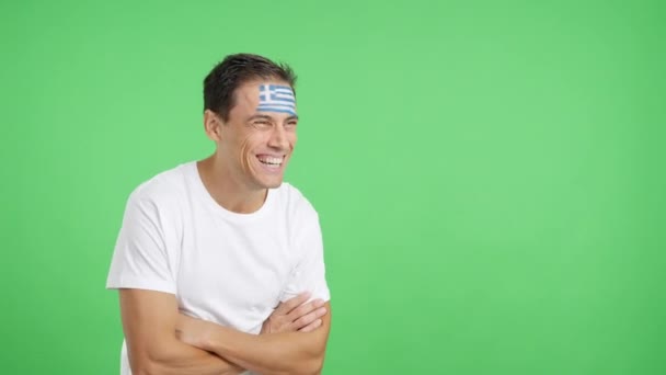 Видео Студии Хромой Счастливого Человека Греческим Флагом Нарисованным Лице Смотрящего — стоковое видео