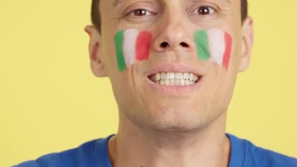 在演播室里用彩色照片近距离拍摄一个脸上挂着意大利国旗的非常紧张的男人的照片 在一场最后以失败告终的艰难的比赛中 他支持着意大利球队 — 图库视频影像
