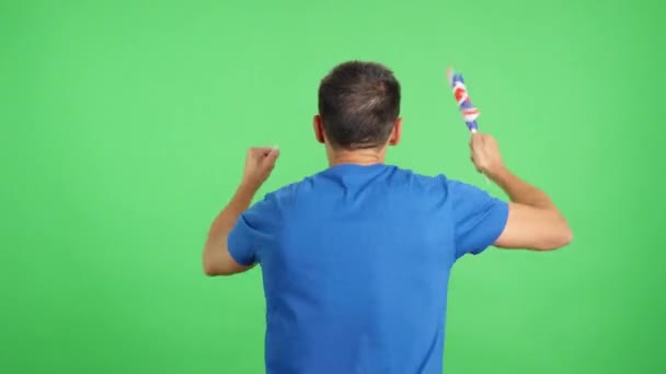 演播室里一个男人挥动着英国国旗后视镜的彩色录像 — 图库视频影像
