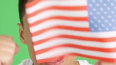 Stüdyoda, yüzü ABD takımını destekleyen bir Amerikan bayrağı taşıyan bir adamın krom görüntüsü var.
