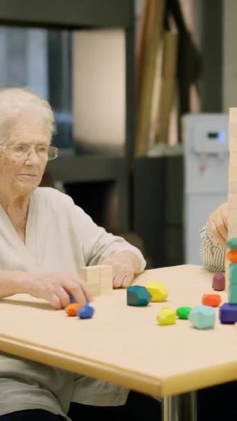 介護施設でスキルボードゲームをしている3人のシニアのビデオ — ストック動画