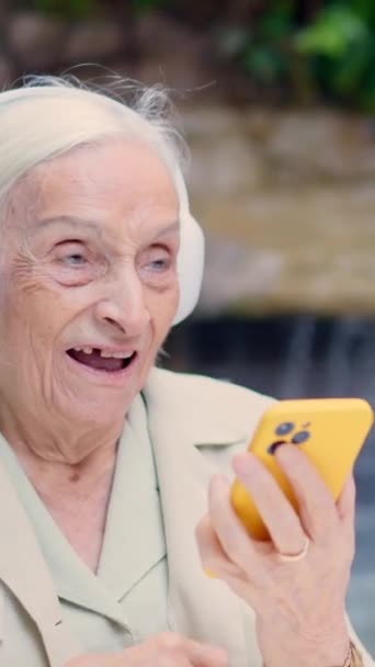 Видео Пожилой Женщины Согласной Музыкой Которую Слушает Мобильном Телефоне — стоковое видео