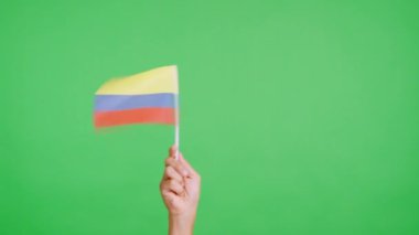 Stüdyoda, Kolombiya bayrağının bayrağını sağa sola sallayan bir elin kromasıyla yavaş çekim videosu.
