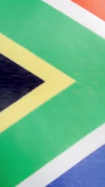 Güney Afrika bayrağının rüzgarda dalgalanan stüdyosundaki dikey yavaş çekim videosu