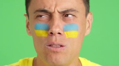 Stüdyoda, yüzünde Ukrayna bayrağı olan çok gergin bir adamın krom rengiyle Ukrayna takımını zor bir maçta destekleyen ve sonunda kaybedilen