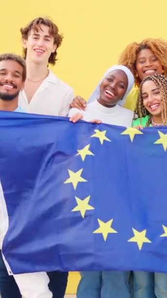 屋外で欧州連合の旗を掲げる多民族集団のスローモーションビデオ — ストック動画