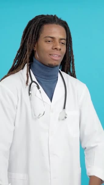 穿着制服的友善的拉汀医生 蓝色背景的工作室的听诊器 — 图库视频影像