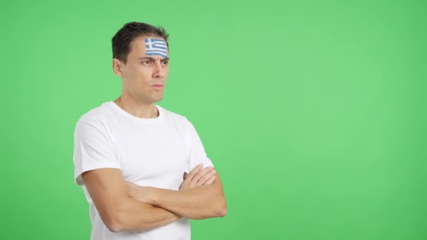 Видео Студии Хромой Человека Греческим Флагом Нарисованным Лице Серьезным Выражением — стоковое видео