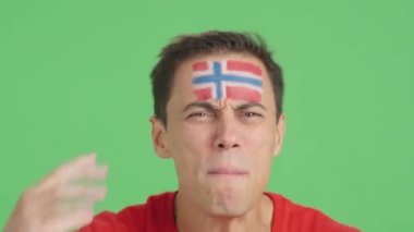 Norveç ulusal bayrağı taşıyan bir adam hakeme kızgın.