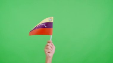 Venezuela bayrağının bayrağını sağa sola sallayan bir elin rengiyle stüdyoda yavaş çekim videosu
