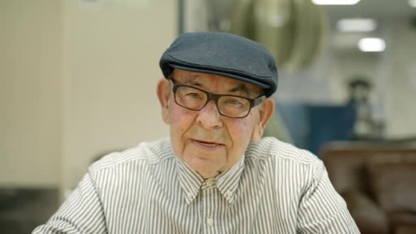 在养老院拍摄的一个老年人头戴贝雷帽对着摄像机说话和微笑的特写视频 — 图库视频影像