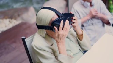 Sanal gerçeklik gözlüğü kullanan yaşlı bir kadının yaşlı bir kadın tarafından çekilmiş videosu.