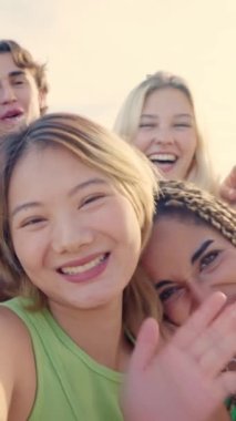 Çok ırklı arkadaşlarıyla dışarıda selfie çeken kendinden geçmiş Çinli bir kadının yavaş çekim videosu.