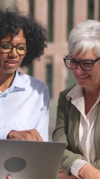 Nagranie Dwóch Bizneswoman Uśmiechniętych Podczas Pracy Laptopem Siedzącym Zewnątrz — Wideo stockowe