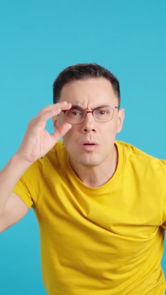 Stüdyoda Mavi Arka Planı Olan Bir Adam Uzağı Göremiyor Gözlüklerini — Stok video