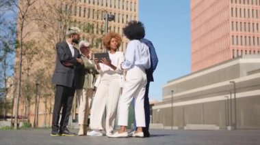 Dijital tablet kullanan çok ırklı iş adamlarının yan yana seyahat ettiği video