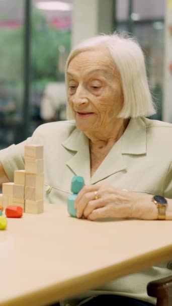 Видео Пожилая Женщина Решает Умственную Игру Деревянными Фигурами Пожилом Возрасте — стоковое видео