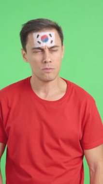 Stüdyoda, Güney Kore milli marşını dinleyen bir adamın krom renkli videosu.