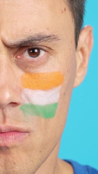 カメラを見ている顔にインドの旗を塗った深刻な男のクローマのスタジオでのビデオ — ストック動画