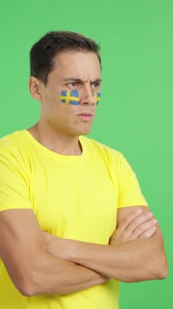 Видео Студии Хромой Человека Шведским Флагом Нарисованным Лице Смотрящим Сторону — стоковое видео
