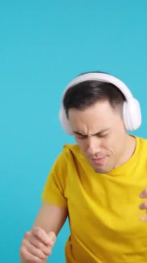 Stüdyoda, dans ederken cep telefonu ve kulaklıkla müzik dinleyen heyecanlı bir adamın mavi arka planlı videosu var. Çerçeve boş başlar, adam aşağıdan görünür.