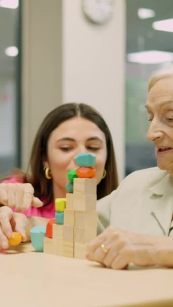 一个护士谈话和帮助一位老妇人解决技能游戏的视频 — 图库视频影像