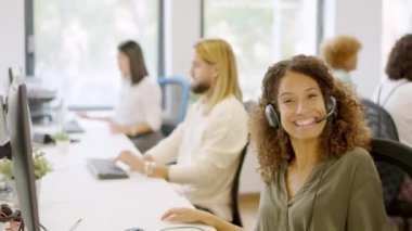 Ofiste kameraya gülümseyen bir kadın telefon operatörünün yavaş çekim videosu.
