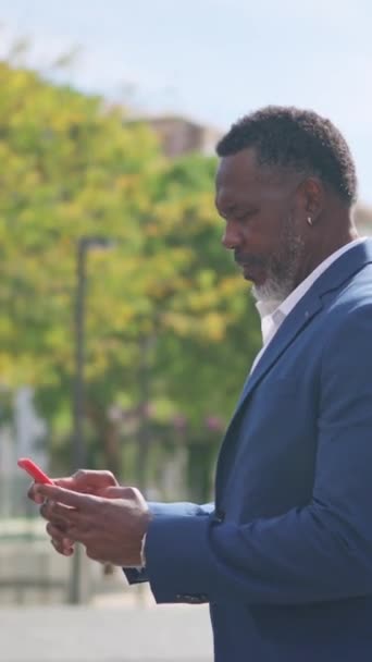 전화로 메시지를 보내는 성숙한 아프리카 사업가의 비디오 — 비디오