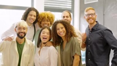 Kameraya gülümseyen çok ırklı bir grup iş arkadaşının yavaş çekim videosu.