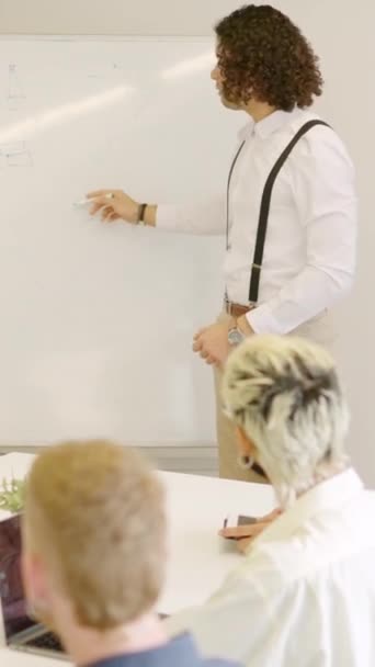 会議室でホワイトボードを使用してアイデアを説明する男性のスローモーションビデオ — ストック動画