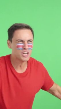 Stüdyoda, Kosta Rika 'ya tezahürat yapan, ulusal bayrak sallayan ve fotokopi çekilen boş yere bakan bir adamın kromasıyla.