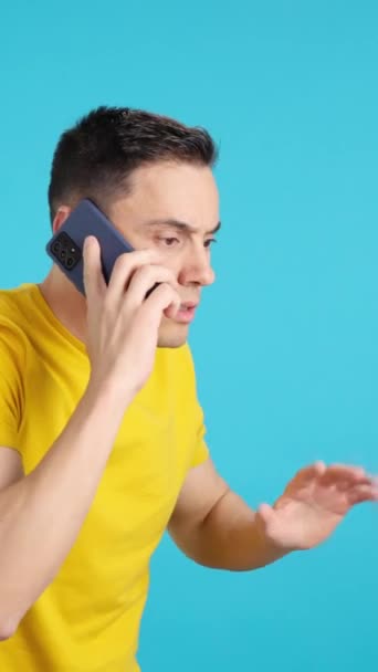 Stüdyoda Cep Telefonuyla Konuşurken Elini Kaldıran Bir Adamın Mavi Arkaplanlı — Stok video