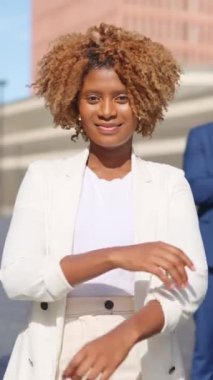 Afrikalı bir iş kadınının kollarını kavuşturup açık havada gülümsemesinin videosu.