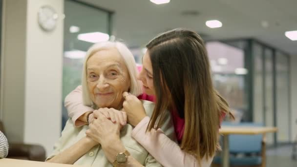 Відео Усміхненої Медсестри Яка Онукою Цілує Приймає Старшу Жінку Геріатрії — стокове відео